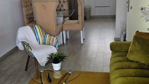 Una sala de estar moderna con sofá, sillones, una mesa de centro y un comedor.