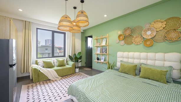 Une chambre moderne comprenant un lit, un canapé, une table à manger et un réfrigérateur.
