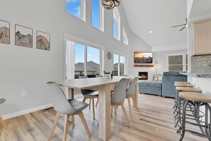 Una cocina amplia con comedor, ventanas grandes y vistas a la montaña.