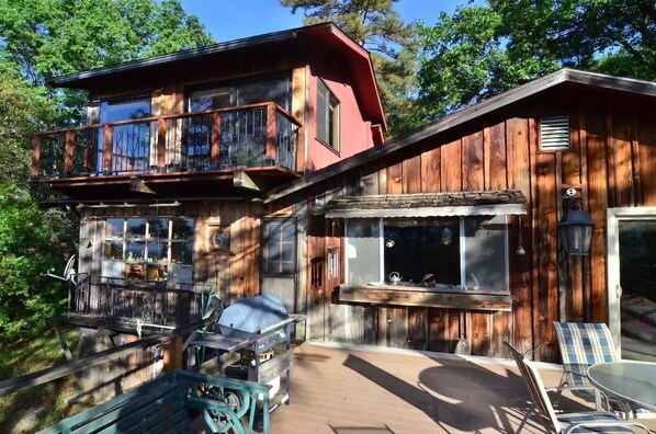 A rustic cabin with a balcony, outdoor seating, and a grill area. - Charming Rustic Mountain Cabin, Near Yosemite,Amazing Views, and a Fireplace (Wishon)