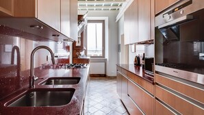A modern kitchen with stainless steel appliances, wooden cabinets, and a tiled floor. - Pantheon View by Interhome (Roma: Piazza Navona - Campo dei Fiori)