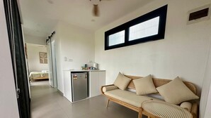 A compact living space with a kitchenette, a sofa, and a small table. - Selah Fiji (Nadi)