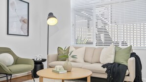 A living room with a sofa, a round coffee table, a floor lamp, and a framed artwork on the wall. - Balaclava City Hub by Ready Set Stay (Balaclava)