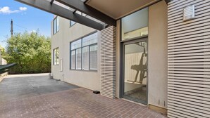 A modern building with large windows and a brick patio. - Balaclava City Hub by Ready Set Stay (Balaclava)