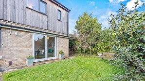 A modern two-story house with a brick facade, large sliding glass doors, and a well-maintained lawn. - Lime Corner: Peaceful with Parking (Leicester)