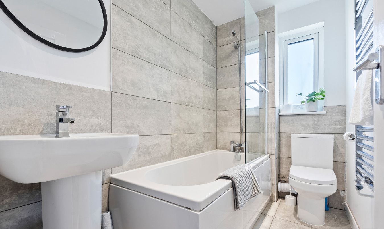 A modern bathroom with a bathtub, sink, and toilet.