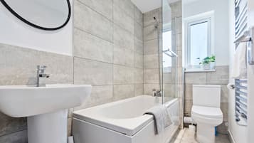 A modern bathroom with a bathtub, sink, and toilet.