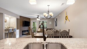 A modern kitchen with a granite countertop, stainless steel sink, and a built-in oven. - Lavish Waterfront Condo 60ft from Table Rock Lake! (Branson)