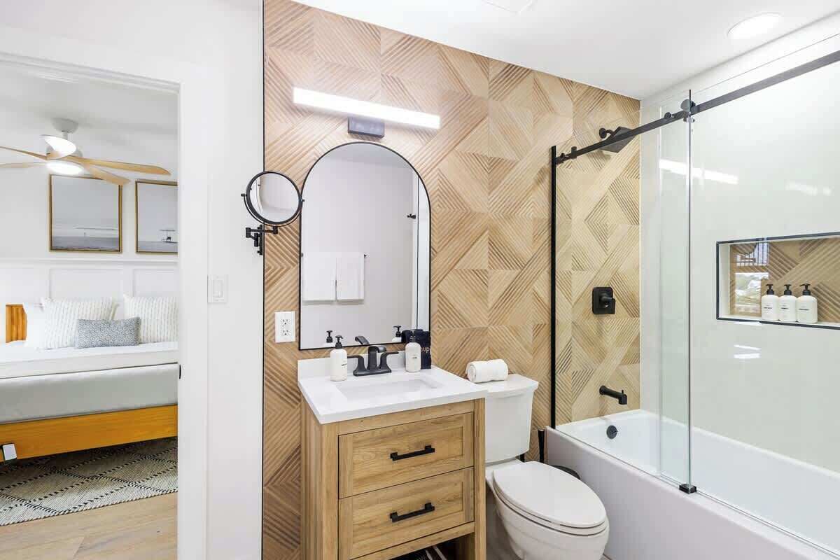 A modern bathroom with a vanity, toilet, and shower.