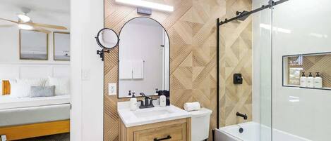A modern bathroom with a vanity, toilet, and shower.