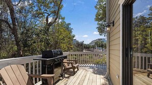A wooden deck with a grill and chairs, overlooking a residential area. - Blue Mountain Beach Getaway | Walk to Beach & Dining | Community Pool (Santa Rosa Beach)