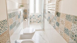 A narrow bathroom with a toilet, a shower, and a sink. - Vertigini Suites (Riomaggiore)
