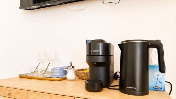 A wooden table with a coffee maker, a kettle, glasses, and a basket. - Vertigini Suites (Riomaggiore)