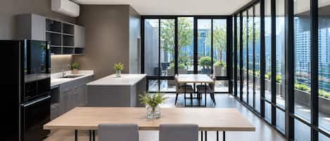 A modern kitchen with a dining area, large windows, and a view of the city.