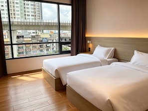 A hotel room with two beds, a large window, and a view of the cityscape. - 35 Bow Hotel (Bangkok)