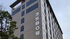 Ein mehrstöckiges Gebäude im modernen Stil, mit einer auffälligen Schrifttafel an der Fassade.