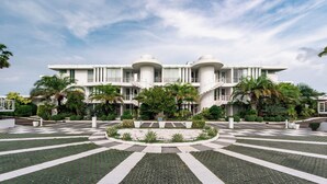A modern building with a symmetrical facade, multiple balconies, and a central circular garden. - Private Sunset Beach - Sea View Studio Room (Sattahip)