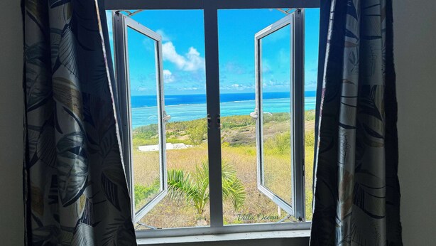 Ein Fenster mit Blick auf den Ozean und ein Schild mit der Aufschrift 'Villa Ocean'.