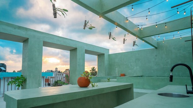 A modern kitchen with a concrete countertop, a sink, and hanging lights. - Hotel Florita39 (Isla Mujeres)