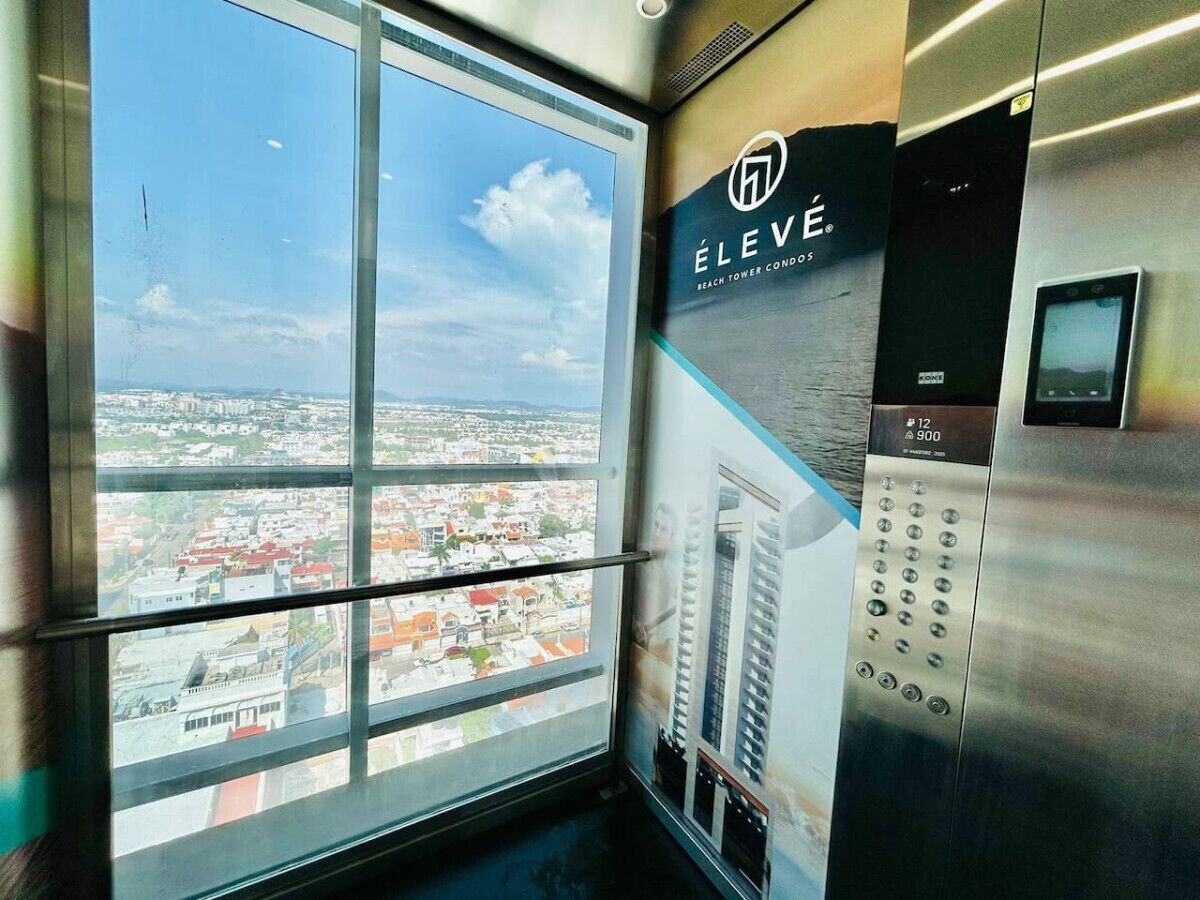 An elevator with a view of a cityscape through a large window.