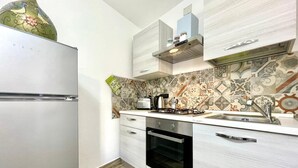 Une cuisine moderne avec un réfrigérateur blanc, une cuisinière, un évier et un four à micro-ondes.