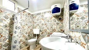 Une salle de bain avec un mur recouvert de carreaux à motifs, des toilettes, un lavabo et une douche.