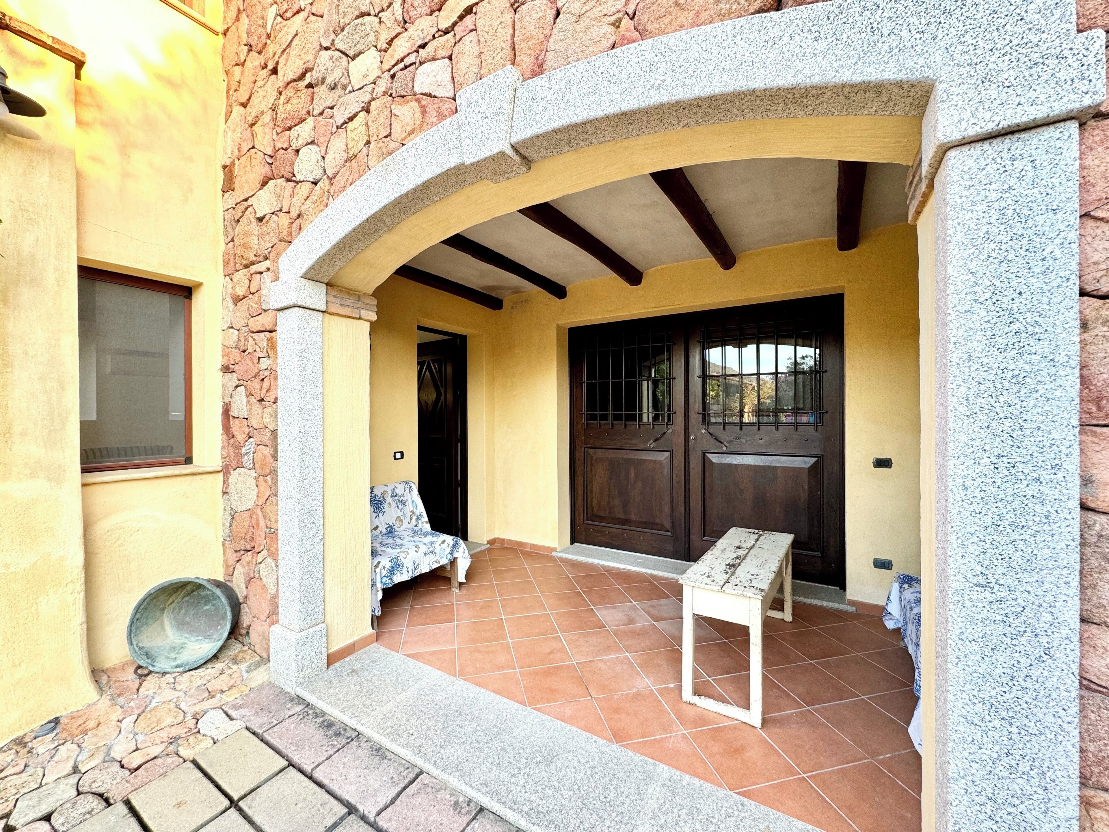 A stone building with a wooden door and a small table in the entrance area.