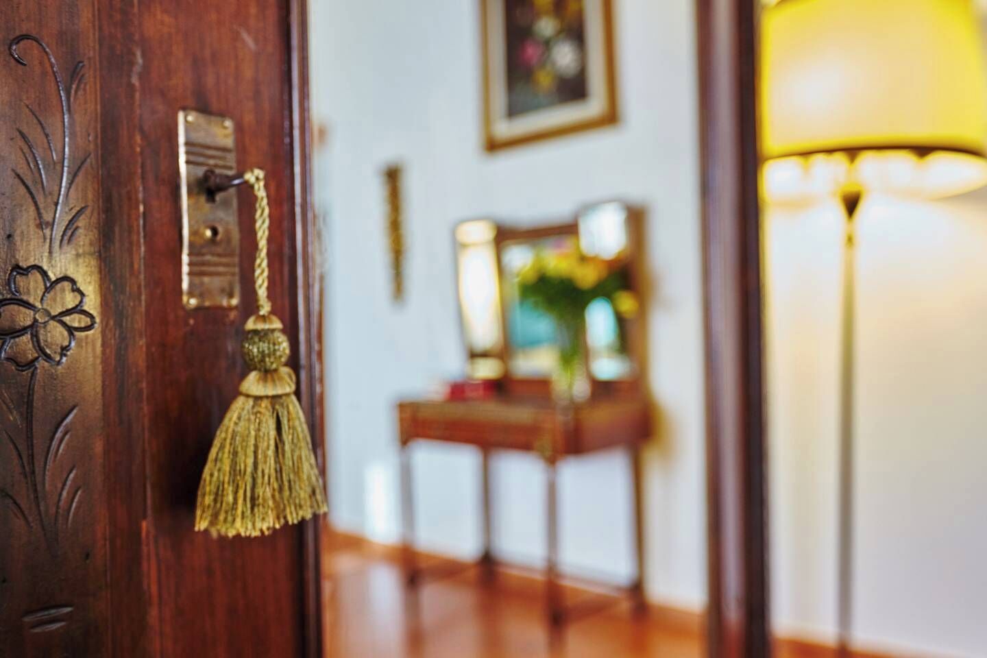 A wooden door with a brass handle and a brass keyhole.