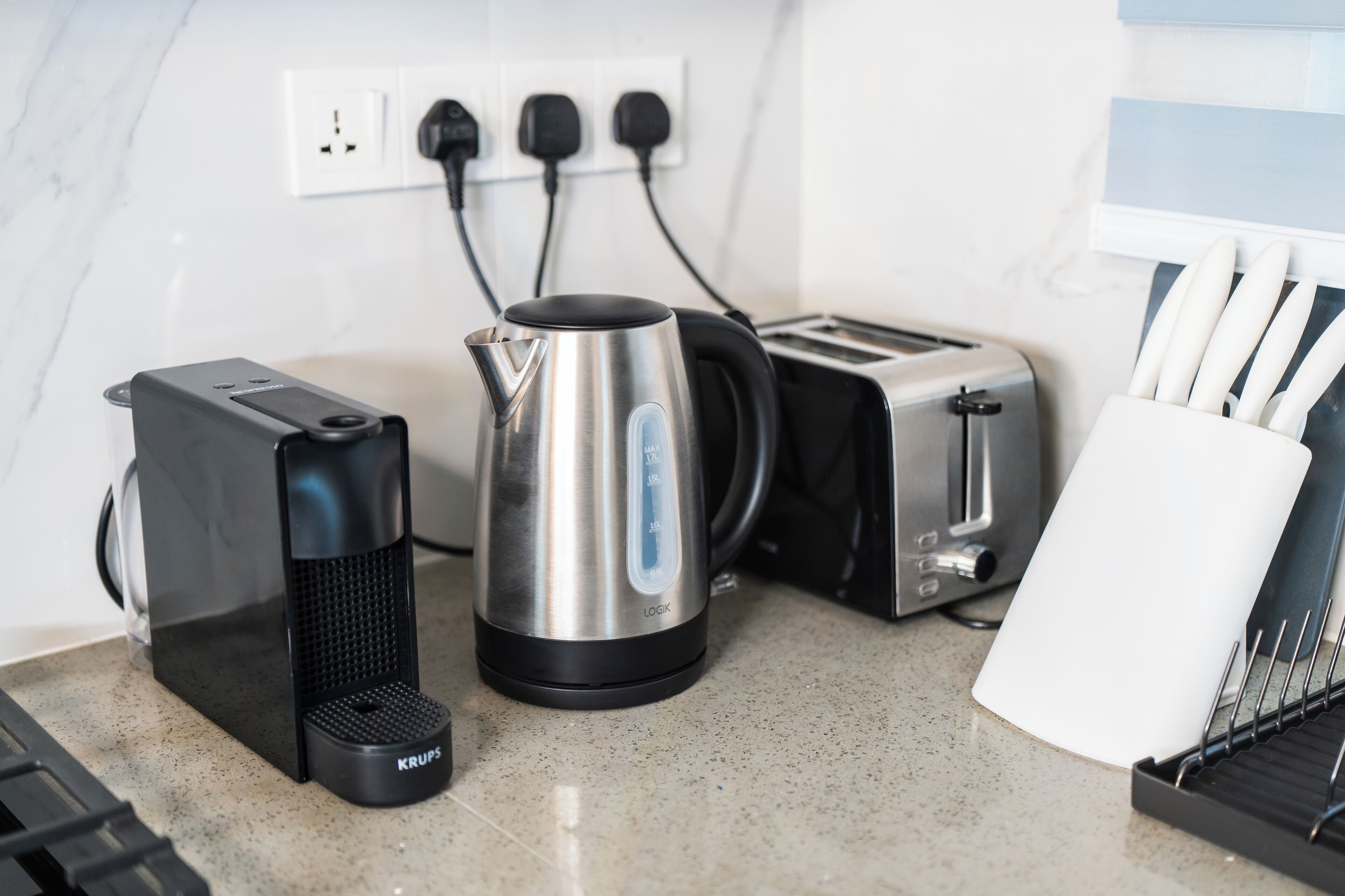 Eine Küche mit Kaffeemaschine, Wasserkocher, Toaster und einem Messerblock.