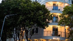 Un hôtel à plusieurs étages, doté de balcons et d’un restaurant situé au rez-de-chaussée.