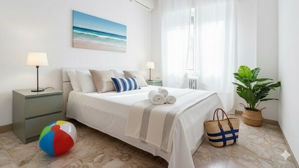 A neatly arranged bedroom with a bed, bedside lamps, a beach-themed painting, a beach ball, and a plant.
