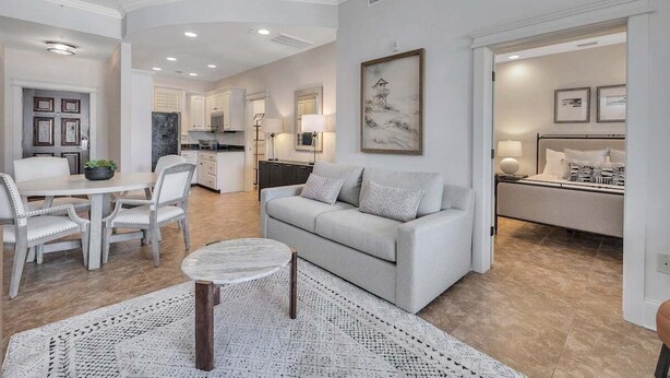 A modern living room with a sofa, coffee table, and dining area. - Gorgeous condo-luxurious interiors, fantastic amenities, near fun St. Simons activities! (Saint Simons Island)