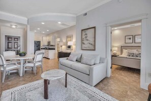Een moderne woonkamer met een bank, salontafel en eethoek.