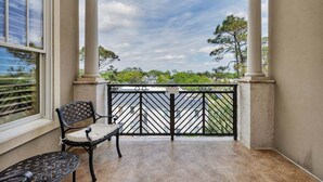 Un balcón con vistas a una zona residencial, una silla y una mesa.