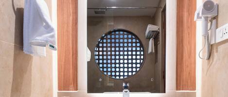 A bathroom with a sink, mirror, towel rack, and a hairdryer.