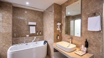 Un bagno moderno con una vasca freestanding, un mobile lavabo e un grande specchio.