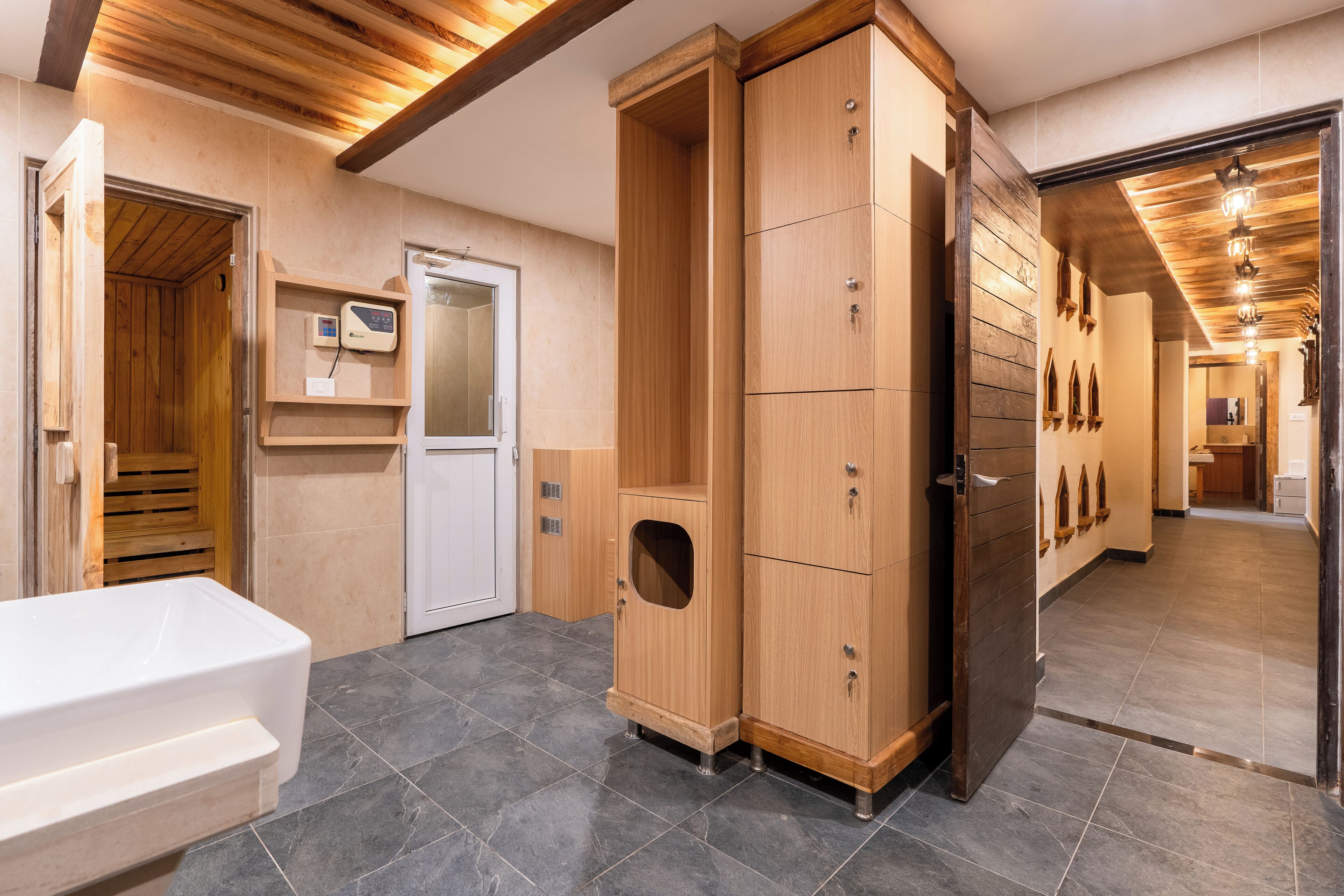 A modern bathroom with a wooden cabinet, a white bathtub, and a sauna.