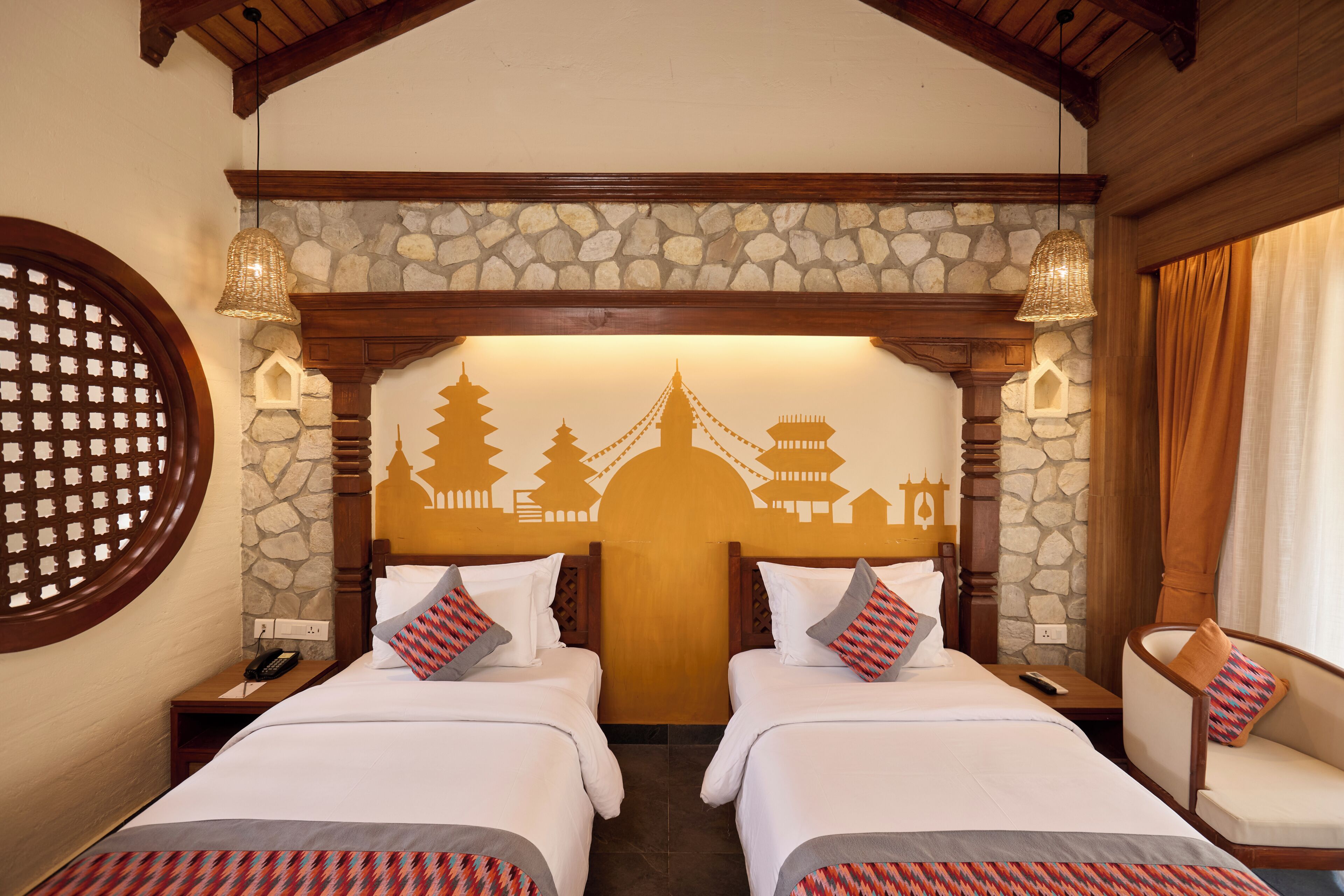 A hotel room with two beds, a stone wall, a wooden ceiling, and a decorative wall mural.