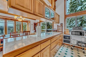 Una cocina amplia con armarios de madera, una isla grande y vistas al exterior.