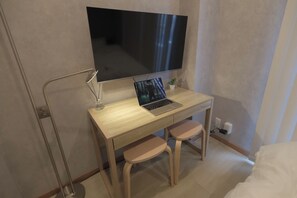 Relax in this compact room with a flat-screen TV, desk, and comfortable seating options.