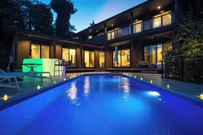 Relax by the pool in a serene outdoor space with a spacious pool and seating area.
