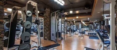 A gym with various exercise equipment, including weight machines and benches.