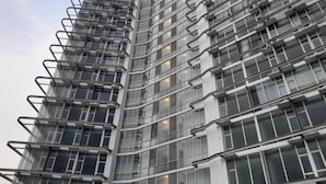 A high-rise building with a modern architectural design, featuring multiple balconies and large windows. - Roket Room Majestic Point (Gading Serpong)