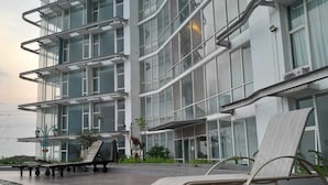 A modern building with multiple floors, large windows, and outdoor seating areas. - Roket Room Majestic Point (Gading Serpong)