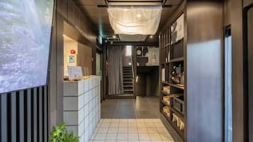 A hotel reception area with a reception desk, a staircase, and a private spa section.
