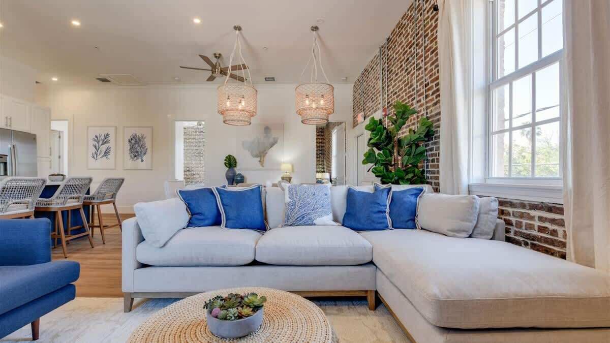 A modern living room with a sectional sofa, a coffee table, and a dining area.
