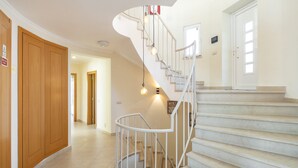 A spiral staircase with a white railing and light bulbs, leading to a landing with a door. - Villa Rosati - Luxury villa with private pool and Jacuzzi close to town center (Carvoeiro)
