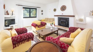 A living room with a sofa set, a coffee table, a fireplace, and a television. - Casa Catarina, Classic Charming Villa with private pool (Carvoeiro)