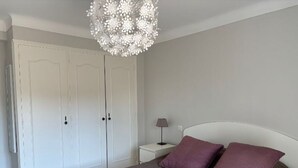 A bedroom with a bed, two pillows, a nightstand, a lamp, and a wardrobe. - Vacation rental 4 people arrière pays grassois (Cabris)
