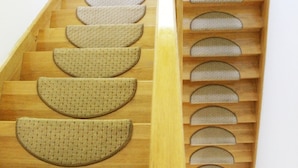 Una escalera de madera con escalones semicirculares alfombrados.